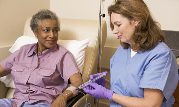 Cancer nurse with patient – as leaders says cancer nurse specialists need to be better valued