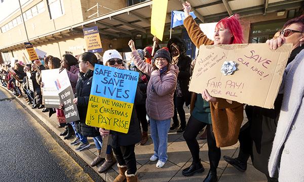 Strikers outside St James’s Hospital in Leeds hold homemade and official RCN placards, some hold their arms in the air and are smiling