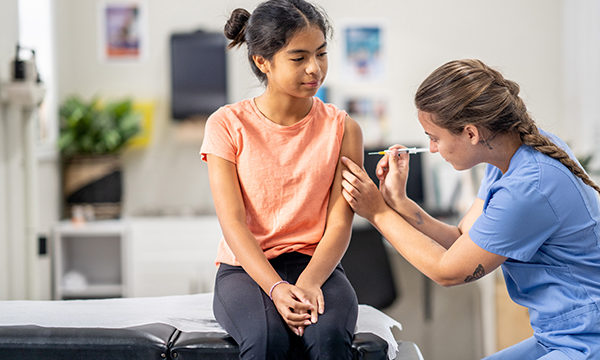 A nurse gives a vaccination to young girl: in the UK numbers show that measles, mumps and rubella (MMR) vaccine uptake among children is in decline and there is a need for increased vaccination coverage