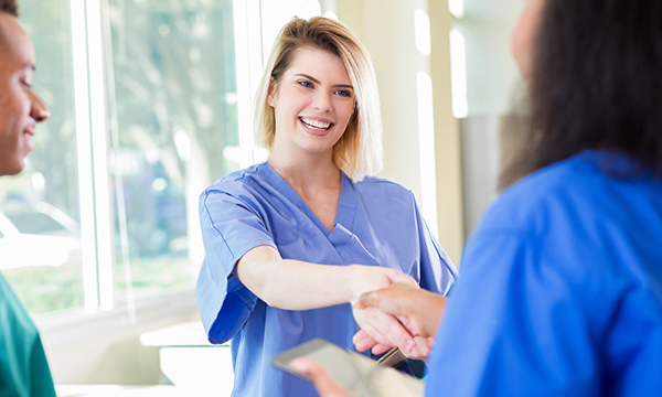 A nurse greeting new colleagues. the Graduate Guarantee scheme aims to ensure that every newly registered nurse and midwife will be able to secure a job
