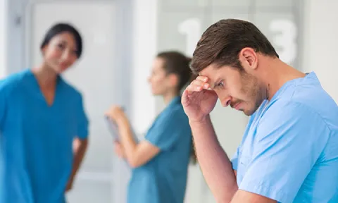 ex discrimination against men in nursing: male staff member appears under stress, female colleagues in the background