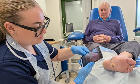 District nurse deputy team leader Lauren Heald uses a smartphone to take a picture of a wound on a patient’s foot