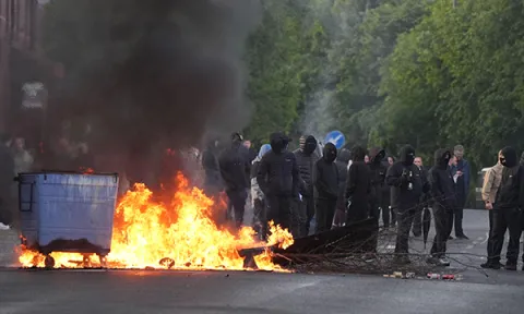 Bins set alight by protesters on Ligoniel Road, Belfast, as disorder flared during a demonstration organised in response to Monday night's stabbing attack in the city. Picture: Alamy