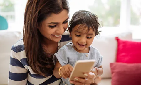 Woman with a small child looking at a smartphone