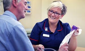 A bowel cancer nurse specialist discusses options with a smiling patient