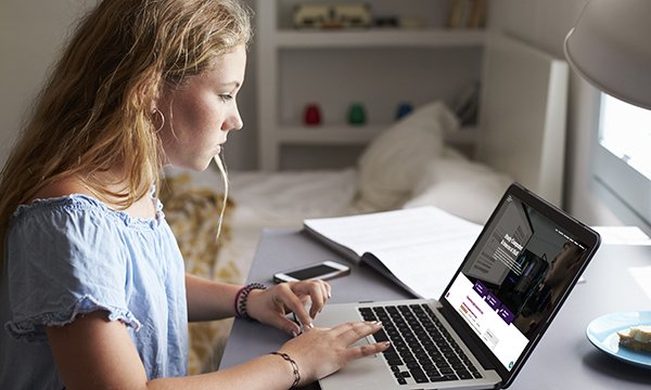 Photo of person using laptop, illustrating story about nursing degree applications falling