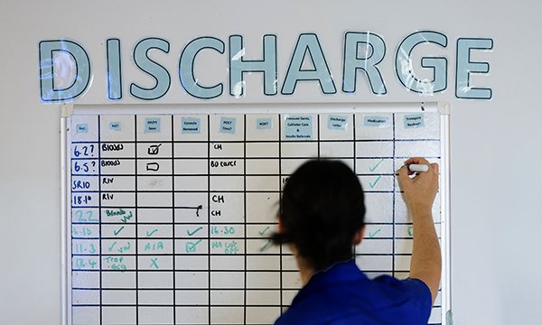 Matrons on wards: senior nurse writes on ward discharge chart