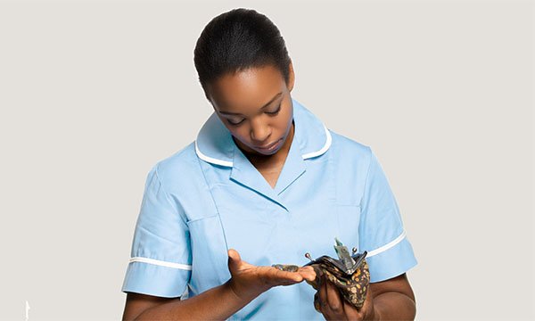 Pay nursing students for placements: student taking small change from her purse