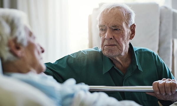 man at woman's bedside