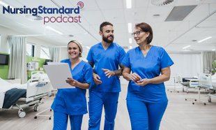 Three nurses walking through a hospital ward, chatting and smiling 