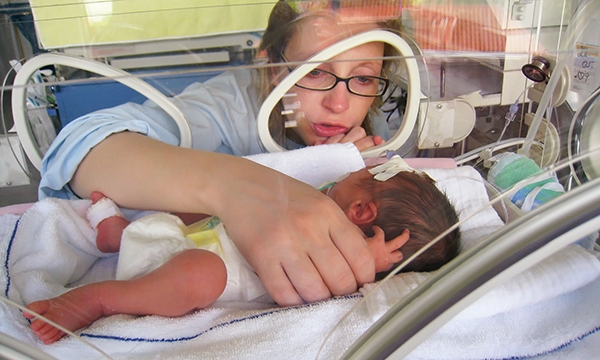 Woman with baby in baby incubator